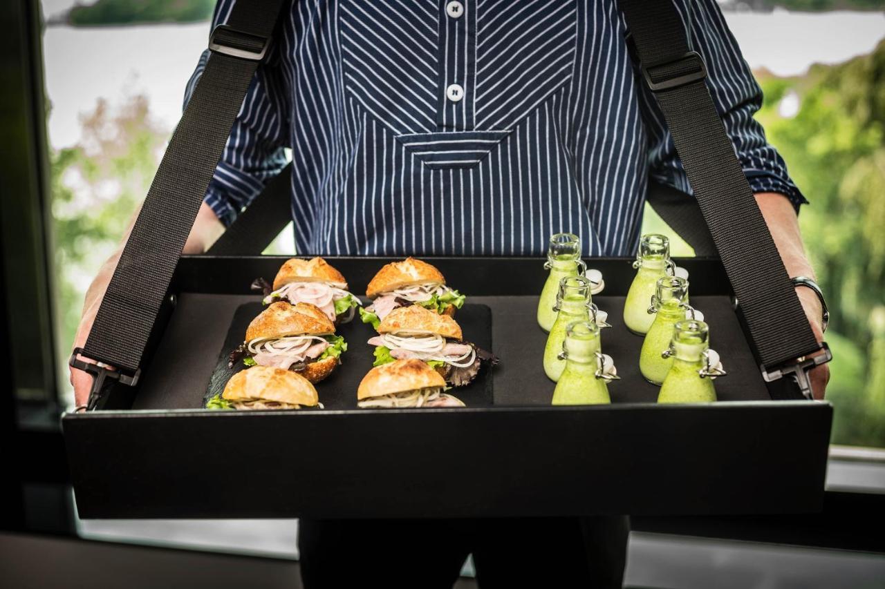 Le Meridien Хамбург Екстериор снимка A waiter holding a tray of food